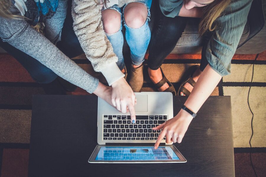 Three women using a laptop