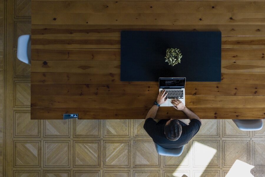 man using laptop at wooden table