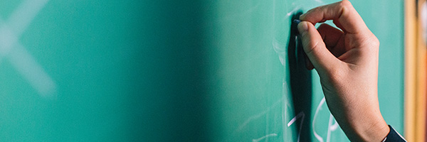 Person writing on a chalkboard