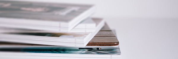 A stack of magazines with an iPad in the middle