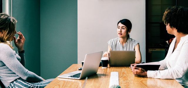 three people holding a meeting