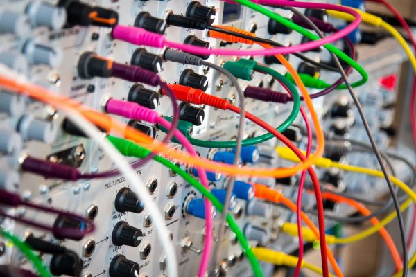 A collection of colourful cables plugged into a machine